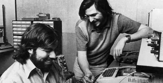 Steve Jobs and Steve Wozniak working together on a workbench, repairing or debugging a computer prototype in the early 1970s.